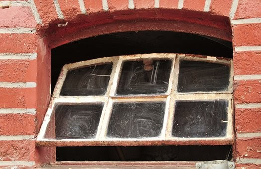 Old and dusty window with worn frame and opaque glazing